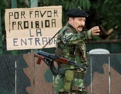 На этой архивной фотографии, датированной 27 июня 2001 г. команданте повстанцев РВСК-АН, Хорхе Брисеньо, известный как ''Моно Хохой'', отдает распоряжения в Ла Макарене. Как заявили колумбийские власти в понедельник, Соединенные Штаты потребовали выдачу военного командующего партизанской армией РВСК-АН Колумбии Бисеньо, наиболее высокопоставленного повстанца из американского списка разыскиваемых. Как заявил представитель офиа генерального рокурора Колумбии, Соединенные Штаты хотят получить Брисеньо, который все еще находится на свободе якобы для того, чтобы заставить его рассказать о производстве и экспорте кокаина на североамериканскую зелю, представитель офиса колумбийского Генерального прокурора сказал. Картина, взятая 27 июня 2001. Надпись на плакате гласит: ''Пожалуйста, проход запрещен''. Фото: 27 июня 2001 г., архив. Анотация: Элиана Апонте, агентство Рейтер, понедельник, 26 апреля 2004 г, 20 ч. 15 мин. всемрного времени