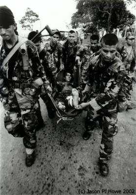 С гримасами на лицах солдаты несут своего товарища в зону
приземления, чтобы дождаться эвакуации. 
Фото и аннотация: Джейсон П.Хоуэ, 2002 г.
