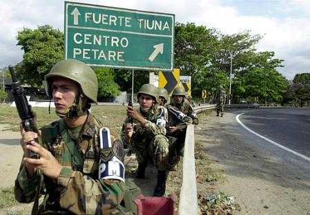 Венесуэльские солдаты охраняют главный вход на 
военную базу Фуэрте Тиуна (Форт Тунца) в Каракасе, 
Венесуэле, 13 апреля 2002 г. Венесуэльский президент 
Уго Чавес ушел в отставку под военным давлением после 
массовой демонстрации оппозиции, завершившейся морем 
крови. Чавес удерживается  на армейской базе Фуэрте Тиуна, 
в Каракасе. Фото и аннотация: Фернандо Льяно, Агентство 
Ассошиэйтед Пресс, 13 апреля 2002 г.