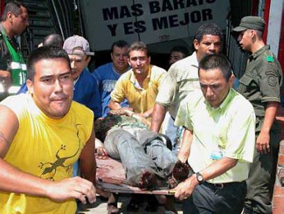 Колумбийские спасатели несут мужчину, раненого в результате взрыва бомбы в популярном торговом центре в Кукуте, 05 марта 2003 г. Бомба взорвалась на месте подземной автостоянки в торговом центре близ северо-восточной границы Колумбии с Венесуэлой, убив по крайней мере четырех человек и ранив 56 других в ходе нападения, ответственность за которое полиция возлагают на левых повстанцев.  Фото и аннотация: Эфраин Патиньо, агентство Ассошиэйтед Пресс, пятница 05 марта 2003 г.; 16 ч. 03 мин. всемирного времени