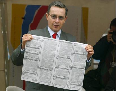 Президент Колумбии Альваро Урибе показывает свой избирательный бюллетень перед голосованием на референдуме по его предложениям, напрвленным  на снижение расходов правительства, уменьшение размера Конгресса и борьбу с политической коррупцией в Боготе, в субботу, 25 октября 2003 г. Фото и анотация: Рикардо Масалан, агентство Ассошиэйтед Пресс, суббота 25 октября 2003 г., 10 ч. 27 мин. всемирного времени.