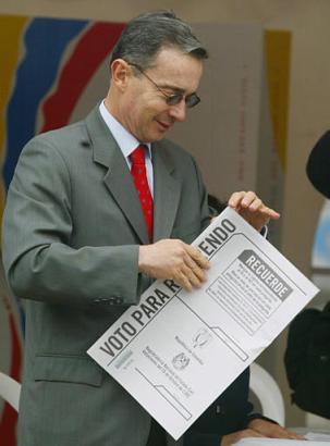Президент Колумбии Альваро Урибе сворачивает свой избирательный бюллетень перед голосованием на референдуме по его предложениям, напрвленным  на снижение расходов правительства, уменьшение размера Конгресса и борьбу с политической коррупцией в Боготе, в субботу, 25 октября 2003 г. Фото и анотация: Хавьер Галеано, агентство Ассошиэйтед Пресс, суббота 25 октября 2003 г., 11 ч. 03 мин. всемирного времени.