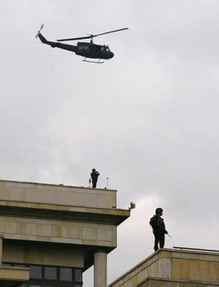 Муха вертолета над солдатами, охраняющими главную площадь Боготы, в то время как президент Колумбии Альваро Урибе голосует на референдуме  по его предложениям, напрвленным  на снижение расходов правительства, уменьшение размера Конгресса и борьбу с политической коррупцией в Боготе, в субботу, 25 октября 2003 г. Фото и анотация: Рикардо Масалан, агентство Ассошиэйтед Пресс, суббота 25 октября 2003 г., 11 ч. 24 мин. всемирного времени.