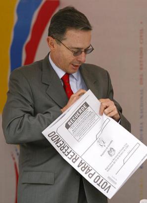 Президент Колумбии Альваро Урибе готовится бросить свой избирательный бюллетень перед голосованием на референдуме по его предложениям, напрвленным  на снижение расходов правительства, уменьшение размера Конгресса и борьбу с политической коррупцией в Боготе, в субботу, 25 октября 2003 г. Фото и анотация: Рикардо Масалан, агентство Ассошиэйтед Пресс, суббота 25 октября 2003 г., 12 ч. 03 мин. всемирного времени.