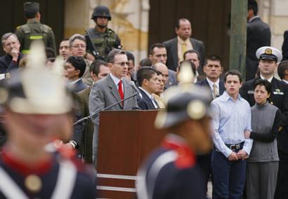 Президент Колумбии Альваро Урибе делает заявление перед голосованием на референдуме по его предложениям, напрвленным  на снижение расходов правительства, уменьшение размера Конгресса и борьбу с политической коррупцией в Боготе, в субботу, 25 октября 2003 г. Справа - его жена Лина Морено и сын Херонимо Урибе. Фото и анотация: Рикардо Масалан, агентство Ассошиэйтед Пресс, суббота 25 октября 2003 г., 13 ч. 05 мин. всемирного времени.
