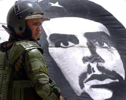 Национальной гвардеец Венесуэлы стоит на посту у Верховного Суда, около эмблемы аргентино-кубинского партизана Че Гевары в ходе демонстрации сторонников венесуэльского Президента Уго Чавеса в Каракасе 16 марта 2004 г. Верховный Суд Венесуэлы удовлетворил надежды чавистов относительно проведения референдума по правилам левого Президента Уго Чавеса, определив в понедельник, что более чем 800 000 подписей, собранных за Чавеса и отклоненных избирательными комисиями, следует считать действительными. Фото и аанотация: Говард Янес, агентство Рейтер, вторник, 16 марта  2004 г., 13 ч. 51 мин. всемирного времени