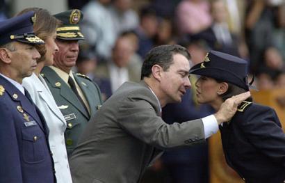 Колумбийский Президент Альваро Урибе, целует офицера военно-воздушных сил после награждения ее в ходе военной церемонии на базе военно-воздушных сил в Кали, в 185 милях к юго-западу от Боготы, в четверг, 05 декабря 2002 г. Слева направо изображены командующий военно-воздушных сил Эктор Веласко, Министр обороны Марта Люсия Рамирес, и главнокомандующий колумбийских вооруженных сил Хорхе Мора. Урибе изучает декларацию перемирия, сделанную в воскресенье национальной полувоенной организацией Объединенные Подразделения Самообороны Колумбии, или AUC, которая испросила правительственного финансирования, поскольку она прекращает вооруженную бьорьбу и оставляет торговлю наркотиками: Фото и аннотация: Освальдо Паэс, агентство Ассошиэйтед Пресс, 05 декабря 2002 г., 07 ч. 26 мин. всемирного времени
