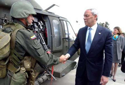 Госсекретарь США Колин Пауэлл приветствует специального колумбийского полицейского в Полицейском Аэропорту, в Боготе, 4 декабря 2002. Как заявили американские должностные лица, Пауэлл находится с двухдневным визитом в Колумбии с тем, чтобы убедить разоренное войной государство, что Вашингтон окажет ему существенную помощь, однако, вместе с тем, он не сможет бороться с партизанами и наркоторговцами  в защиту правительства. Фото и аннотация: Ксавьер Каселья, агентство  Рейтер; 04 декабря 2002 г.; 02 ч. 06 мин. всемирного времени. 
