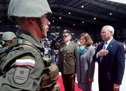 Госсекретарь США Колин Пауэлл (справа), сопровождаемый Министром обороны Мартой Люсией Рамирес (левее) и колумбийским Главным Полицейским Генералом Теодоро Кампо (левее), участвует в церемонии в честь убитых полицейских в Полицейском Аэропорту в Боготе, 4 декабря 2002 г. Как заявили американские должностные лица, Пауэлл находится с двухдневным визитом в Колумбии с тем, чтобы убедить разоренное войной государство, что Вашингтон окажет ему существенную помощь, однако, вместе с тем, он не сможет бороться с партизанами и наркоторговцами  в защиту правительства. Фото и аннотация: Ксавьер Каселья, агентство  Рейтер; 04 декабря 2002 г.; 04 ч. 13 мин. всемирного времени. 
