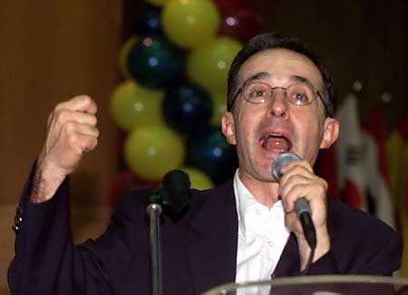 Колумбийский кандидат в президенты Альваро Урибе выступает с речью на политической встрече в Боготе 19 мая 2002 г. При повышенных мерах безопасности кандидаты, выдвинутые колумбийское президентсво для выборов 26 мая, закончили свою кампанию в воскресенье, при этом опросы продемонстрировали подавляющее превосходсьво Альваро Урибе, кандидата-антиповстанца, которому электоральное большинства может позволить избежать последнего тура голосования в июне. Фото и аннотация: Даниэль Муньос, агентство Рейтер,  19 мая 2002 г.
